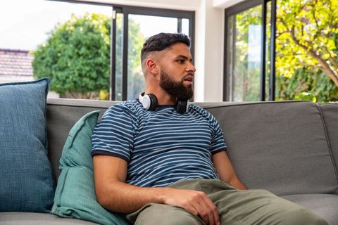 Casual relaxation: man lounging on sofa with headphones