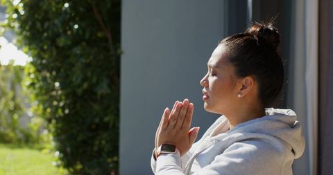 Woman Practicing Mindfulness Outside Against Sunlit Garden