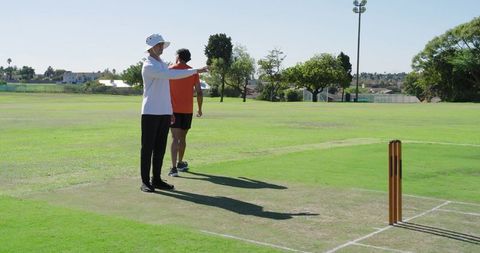 Indian bowler appealing to umpire while teammate walking across cricket pitch