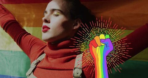 Confident woman embracing pride with rainbow fist graphic and vibrant flag backdrop