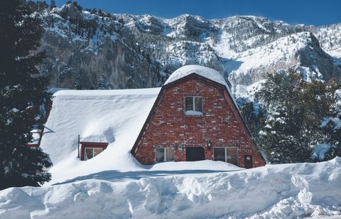 Rustic Snow-Covered Cabin Amidst Breath-Taking Mountain Scenery