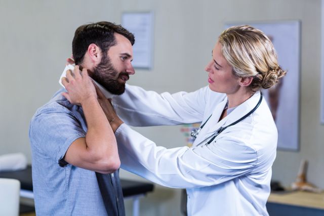 Physiotherapist examining neck of patient in the clinic