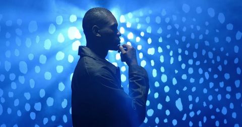 Thoughtful Man in Silhouette with Blue Bokeh Lights