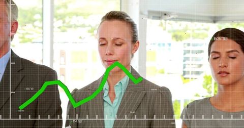 Team practicing mindfulness breathing with green data graph overlay in modern office