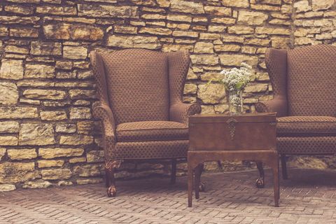 Vintage Armchairs Against Rustic Stone Wall
