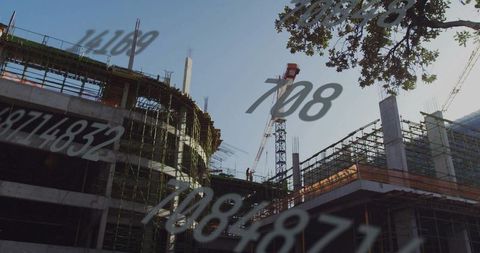 Urban construction site overlaying data readouts while workers inspect scaffold and crane