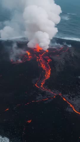 Drone capturing volcanic vent erupting with lava river flowing to ocean and steaming plume