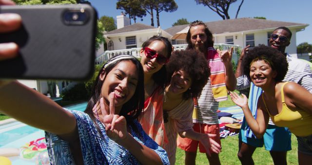 Diverse group of friends taking selfie at a pool party. Hanging out and relaxing outdoors in summer.