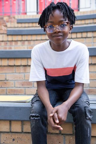 African American Boy with Glasses Sitting on Urban Steps