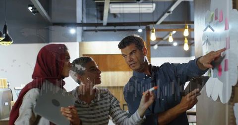 Diverse team collaborating on sticky-note planning in modern coworking office