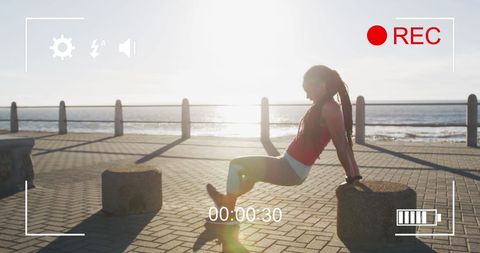Exhausted athlete resting on promenade after workout at sunset