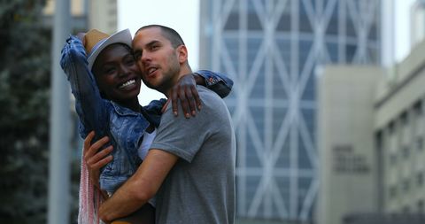 Mixed race couple embracing outdoors in urban setting