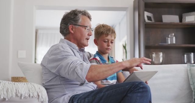 Grandfather Teaching Grandson Using Digital Tablet at Home - Download Free Stock Images Pikwizard.com