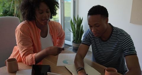 African american couple collaborating on work project at home
