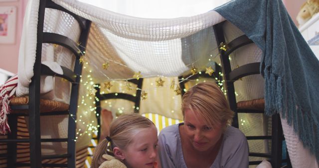Mother and daughter playing together in homemade blanket fort with fairy lights - Download Free Stock Images Pikwizard.com