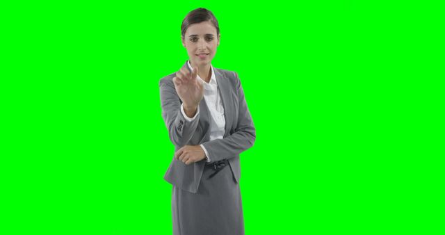 Businesswoman interacting with touchscreen technology in business suit using green screen background. Ideal for digital presentations, corporate training, and technology demonstrations.