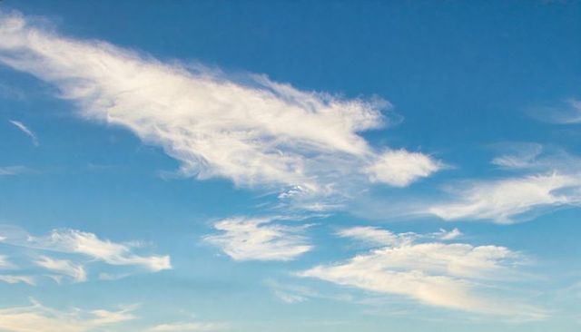 Drifting cirrus clouds over expansive blue sky minimalist serene vertical video background