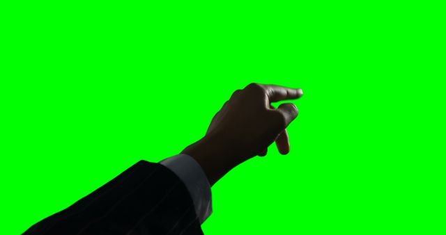 Hand pointing against green screen background suggests interaction with digital interfaces. Useful for presentations, technology-related content, or illustrating concepts like direction and guidance in a business setting.
