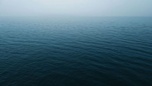 Calm Ocean Surface Beneath Hazy Skies