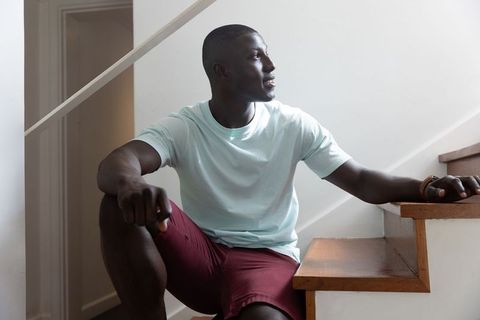 Man Resting on Staircase Wearing Casual Attire at Home