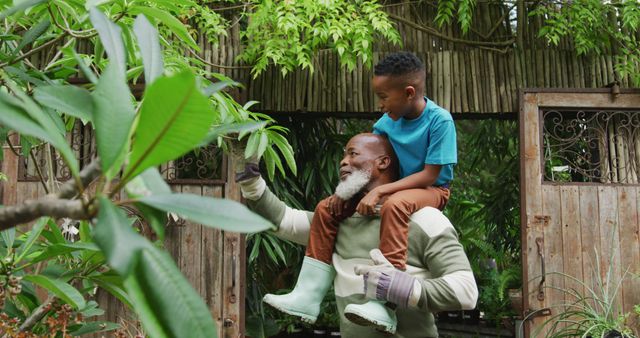 Grandfather Carrying Grandson in Garden - Download Free Stock Images Pikwizard.com