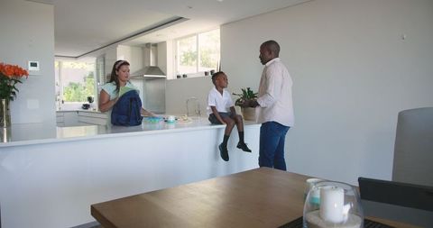 Parents preparing son for school morning routine in kitchen