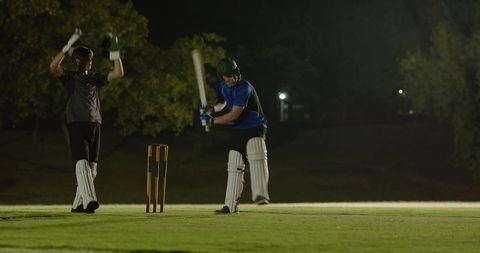 Night cricket training under floodlights batsman connecting shot during intense practice