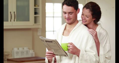 Relaxed Morning Routine with Young Couple Reading Newspaper