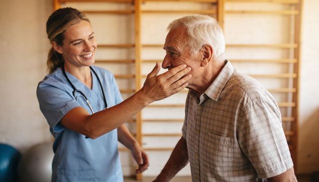 Female nurse guiding elderly man through balance and posture exercise in rehab gym