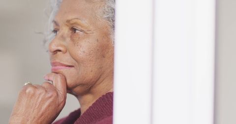 Senior Woman Gazing Out Window in Reflective Pose