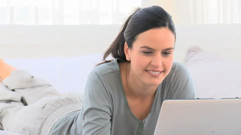 Smiling Woman Using Laptop in Cozy Home Setting
