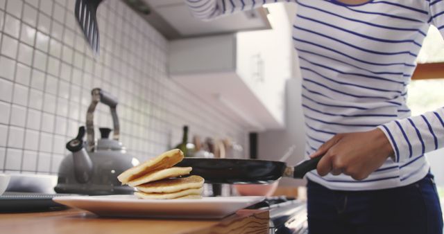 Woman Flipping Pancakes in Modern Kitchen - Download Free Stock Images Pikwizard.com