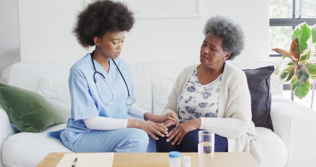 Nurse offers support to elderly woman at home, showcasing role of home healthcare professionals. Good for healthcare brochures, senior care resources, and articles on home nursing, empathy, elderly care.