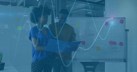 Collaborating over project plans with whiteboard diagrams and sticky notes in modern office