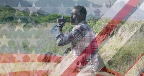 American flag overlay on african american man refreshing in nature