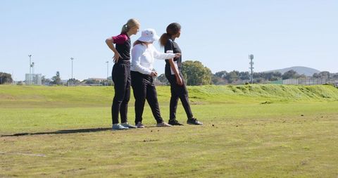 Female coach guiding athletes on playing field