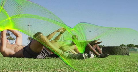 Group core training on turf with stacked tires and neon motion overlay, outdoor fitness