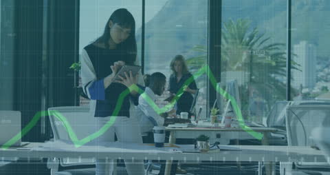 Business Professional Using Tablet with Graphs Overlay in Modern Office