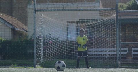Young Goalkeeper Defending Soccer Goal on Artificial Turf