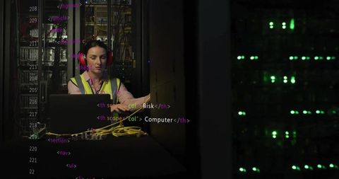 Female technician monitoring server rack wearing high-visibility vest and red headphones
