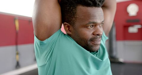 Fit African American man stretching at gym for flexibility
