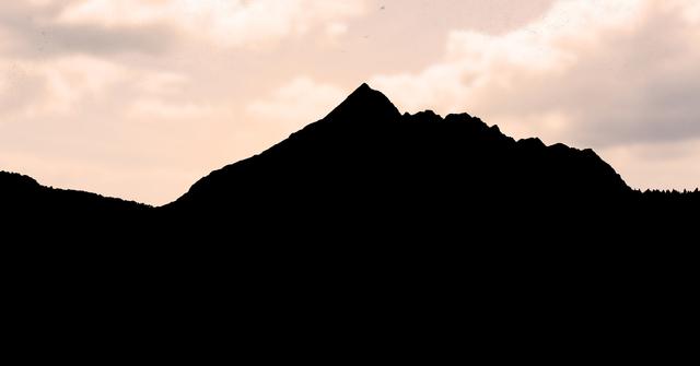 This image captures the silhouette of a mountain against a vibrant sunset sky, creating a dramatic and peaceful scene. Ideal for use in travel brochures, nature blogs, inspirational posters, and background images for websites or presentations.
