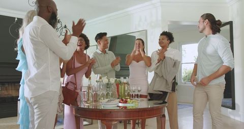 Friends Gathering at Home Celebrating with Drinks and Snacks