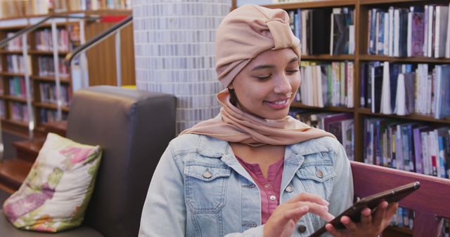 Woman in Headscarf Using Tablet in Library with Happy Expression - Download Free Stock Images Pikwizard.com