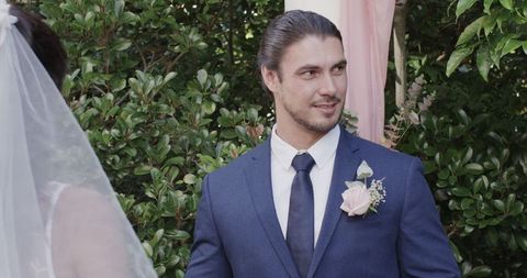 Groom joyfully speaking to bride at outdoor wedding ceremony