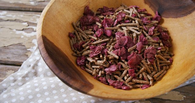 A wooden bowl is filled with dry pet food pellets, with copy space. Pet owners often choose such nutritious kibble to ensure a balanced diet for their animals.