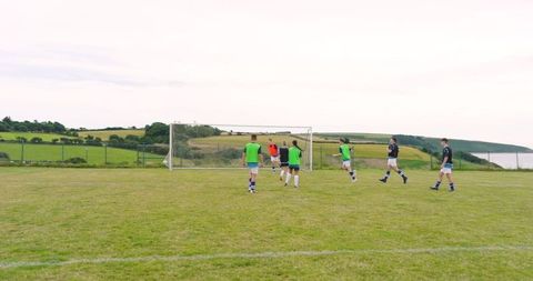 Diverse soccer team practicing during game on scenic coast