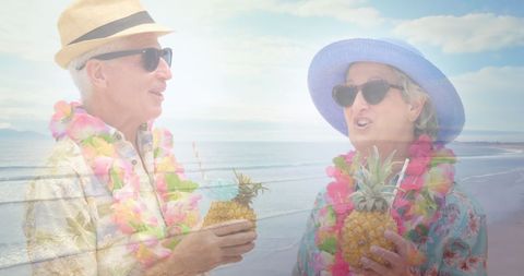 Senior couple enjoying tropical drinks on beach
