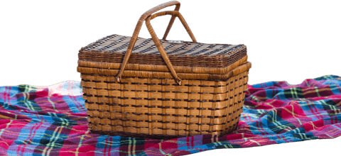 Rustic wicker picnic basket on colorful plaid fabric transparent