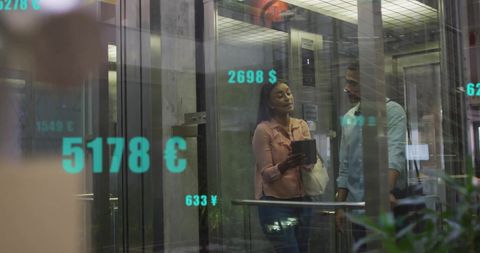 Colleagues in Modern Office Discussing with Digital Financial Data Overlay